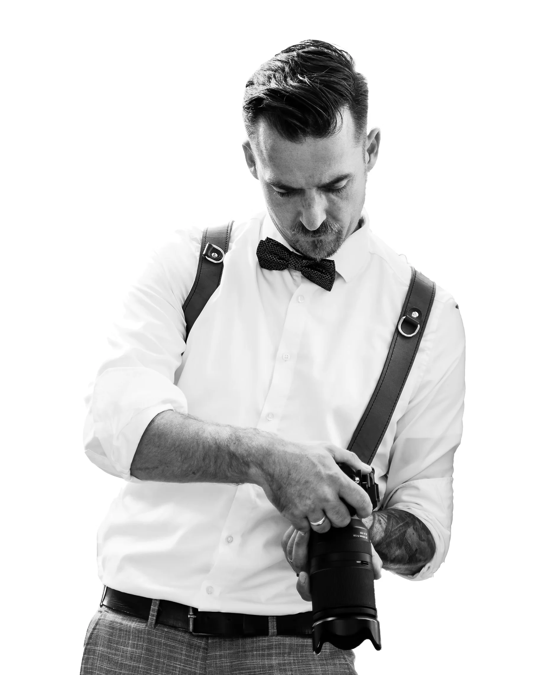 Carsten Seidel mit Kamera, weißem Hemd, Fliege und Ledergurt
