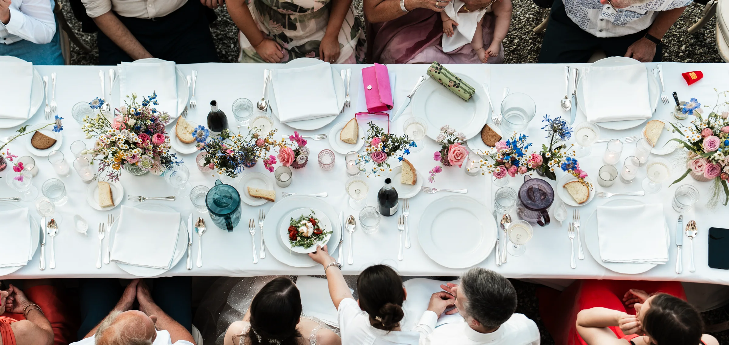 Festlich gedeckter Hochzeitstisch mit farbenfrohen Blumen und Gästen
