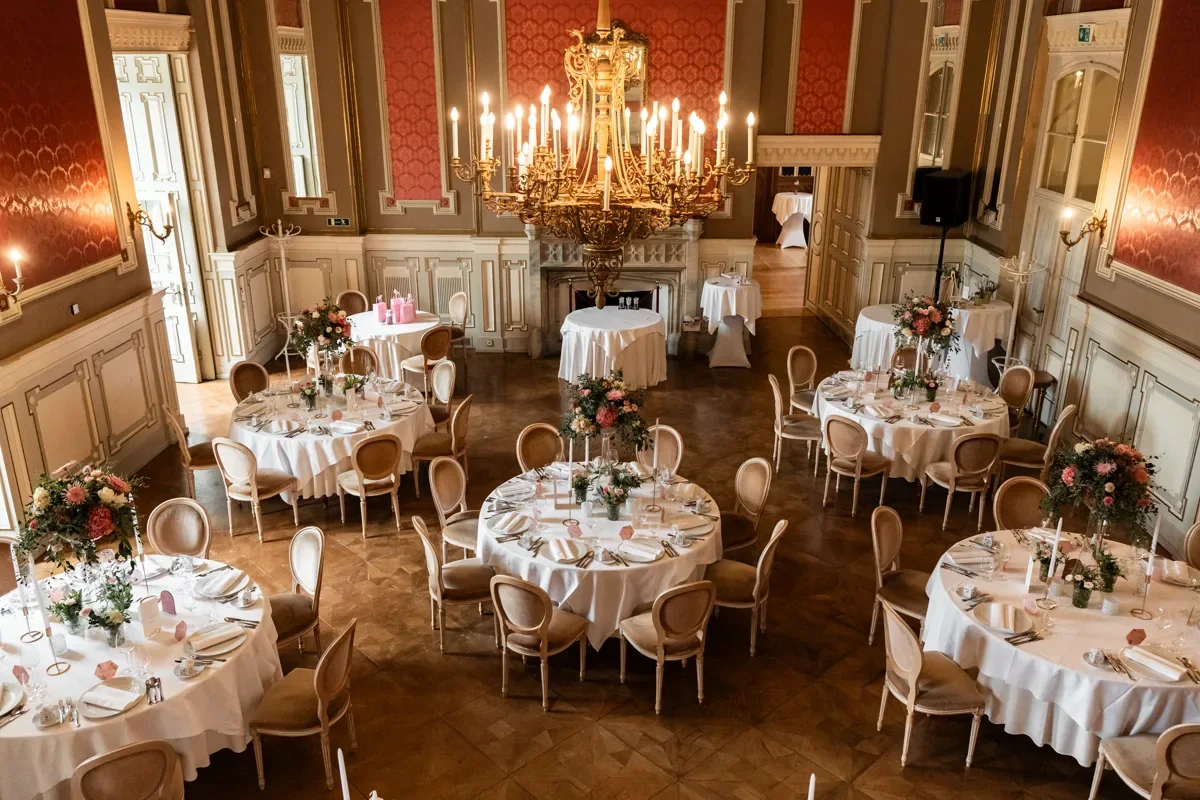 Historischer Festsaal mit runden, gedeckten Tischen