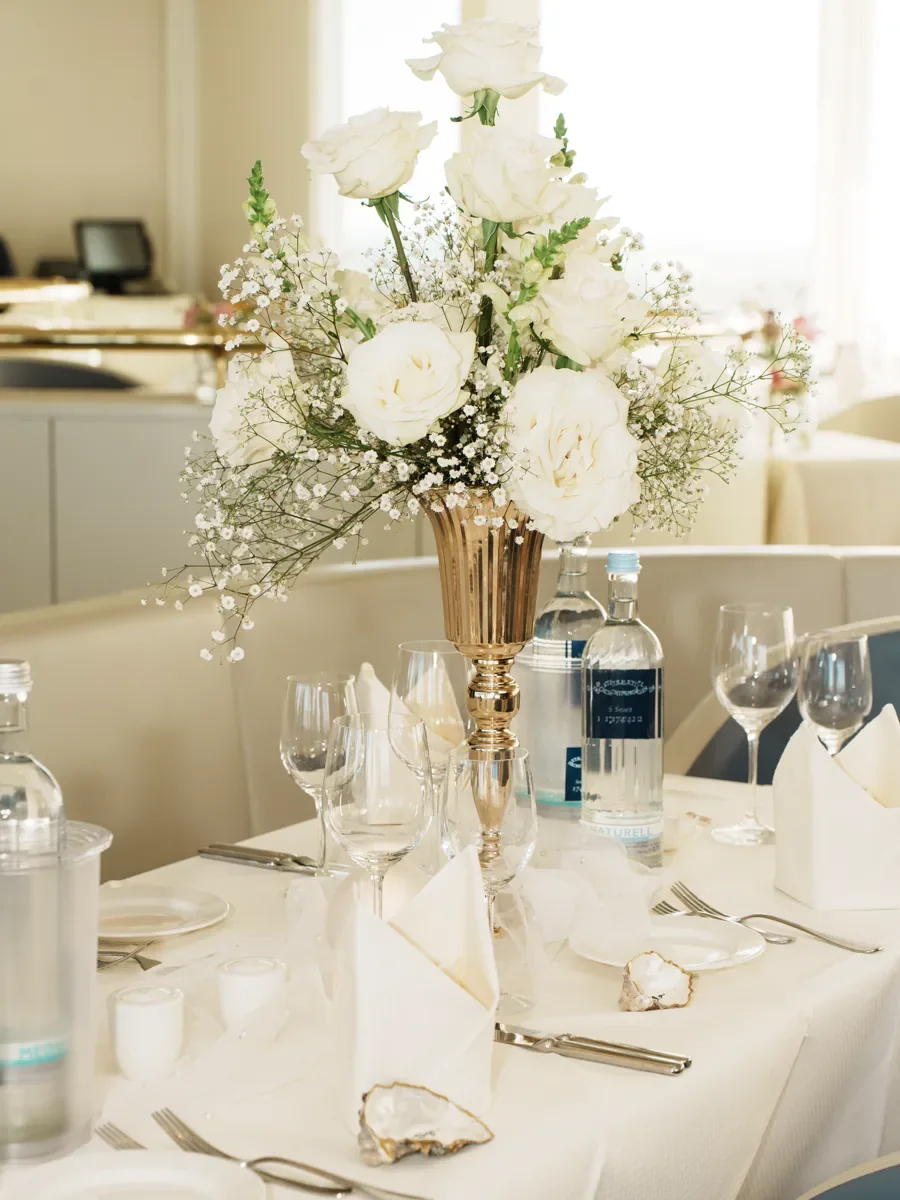 Weiße Blumen auf einer gedeckten Hochzeitstafel
