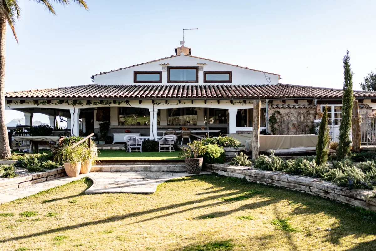 Helles Haus mit Garten unter blauem Himmel