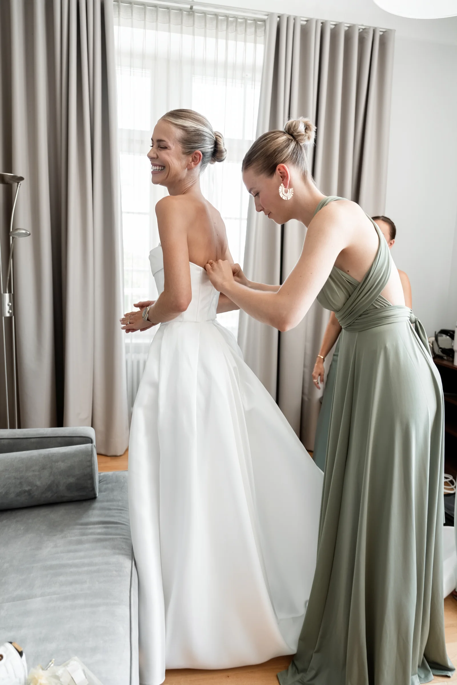 Braut bekommt das Kleid zugemacht
